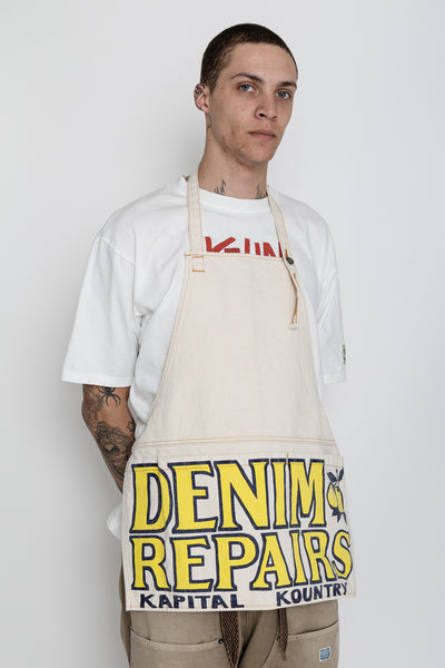 Kapital 2023 Spring Summer advertising apron with a vintage-like logo 3 pockets with different sizes. Featured on the apron is yellow Novelty typography. 13oz distressed denim. Color: Ecru 100% Cotton Made in Japan. 