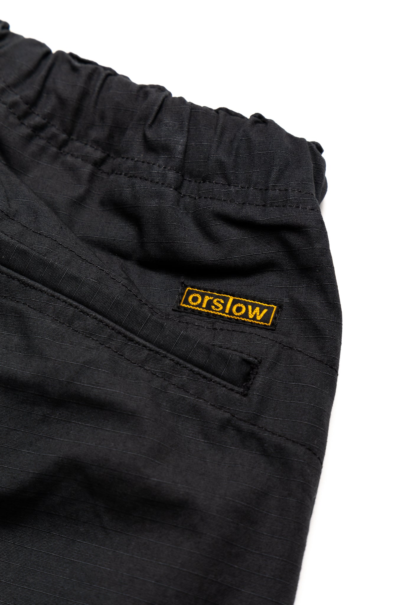 Orslow's easy to wear trousers with an elastic waist and cord drawstring made in Japan. 100% cotton ripstop fabric. Straight leg with a slight taper that features two front pockets and one back. 