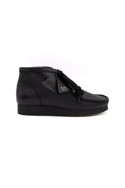 Clark's Original Wallaby Boot in Black Leather. With rugged leather uppers for a premium feel, this silhouette sits atop a chunky pebble crepe sole to stay true to its design DNA, while waxy laces and tonal fobs complete this stone cold classic. Premium black leather upper Natural rubber pebble crepe sole Finished with two Clarks Originals fobs