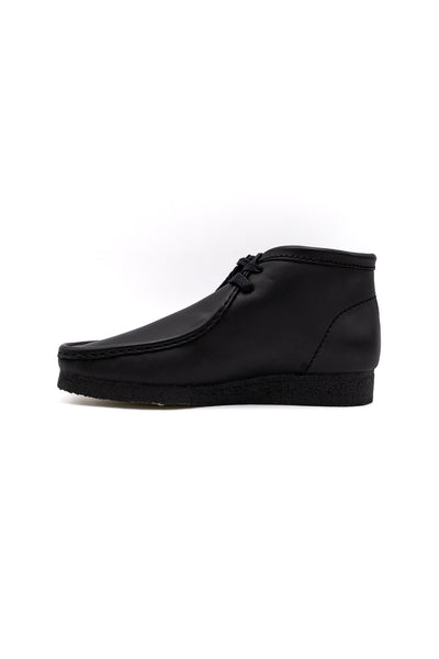Clark's Original Wallaby Boot in Black Leather. With rugged leather uppers for a premium feel, this silhouette sits atop a chunky pebble crepe sole to stay true to its design DNA, while waxy laces and tonal fobs complete this stone cold classic. Premium black leather upper Natural rubber pebble crepe sole Finished with two Clarks Originals fobs