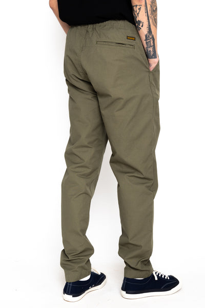 Easy to wear Orslow trousers with an elastic waist and cord drawstring made in Japanese 100% cotton ripstop fabric. Straight leg with a slight taper that features two front pockets and one back. Color: Army Green. Fabric: 100% Cotton. Unisex. Made in Japan.