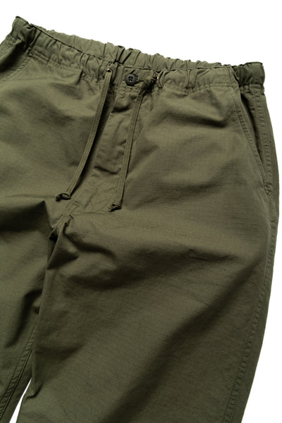 Easy to wear Orslow trousers with an elastic waist and cord drawstring made in Japanese 100% cotton ripstop fabric. Straight leg with a slight taper that features two front pockets and one back. Color: Army Green. Fabric: 100% Cotton. Unisex. Made in Japan.