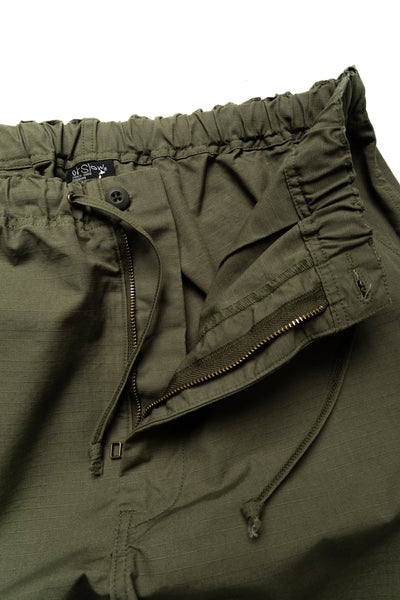 Easy to wear Orslow trousers with an elastic waist and cord drawstring made in Japanese 100% cotton ripstop fabric. Straight leg with a slight taper that features two front pockets and one back. Color: Army Green. Fabric: 100% Cotton. Unisex. Made in Japan.