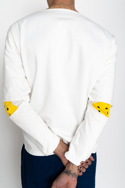 Kapital white long sleeve boatneck made of a densely knit knit jersey fabric. Features a signature Kapital motif print peeking through the slit in the elbow. Color: White. Made in Japan 100% cotton. There are cracks due to the characteristics of the print, but it is not a product defect because it is due to the intention of the design. Unisex. 